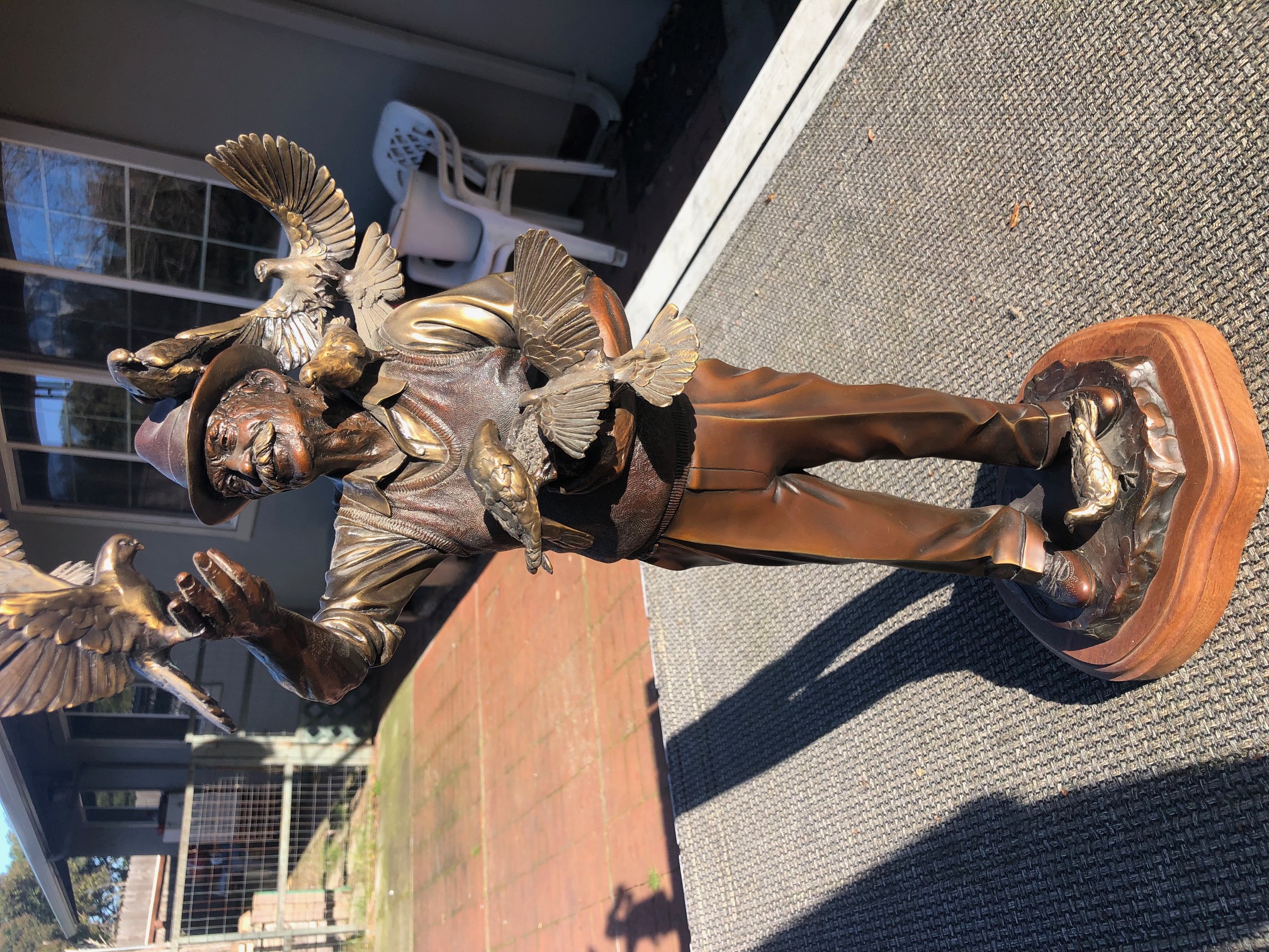 BRONZE SCULPTURE OF A MAN HOLDING PIGEONS. 